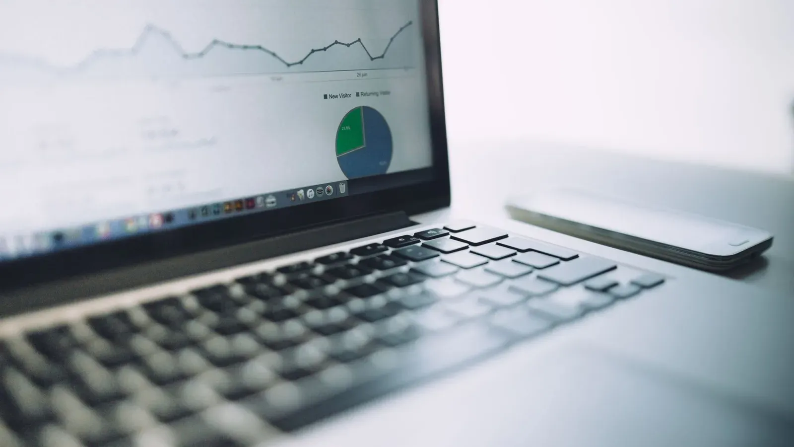 Ein Laptop, der ein Analyse-Dashboard mit Diagrammen und Grafiken zeigt und moderne Datenanalysetools symbolisiert.