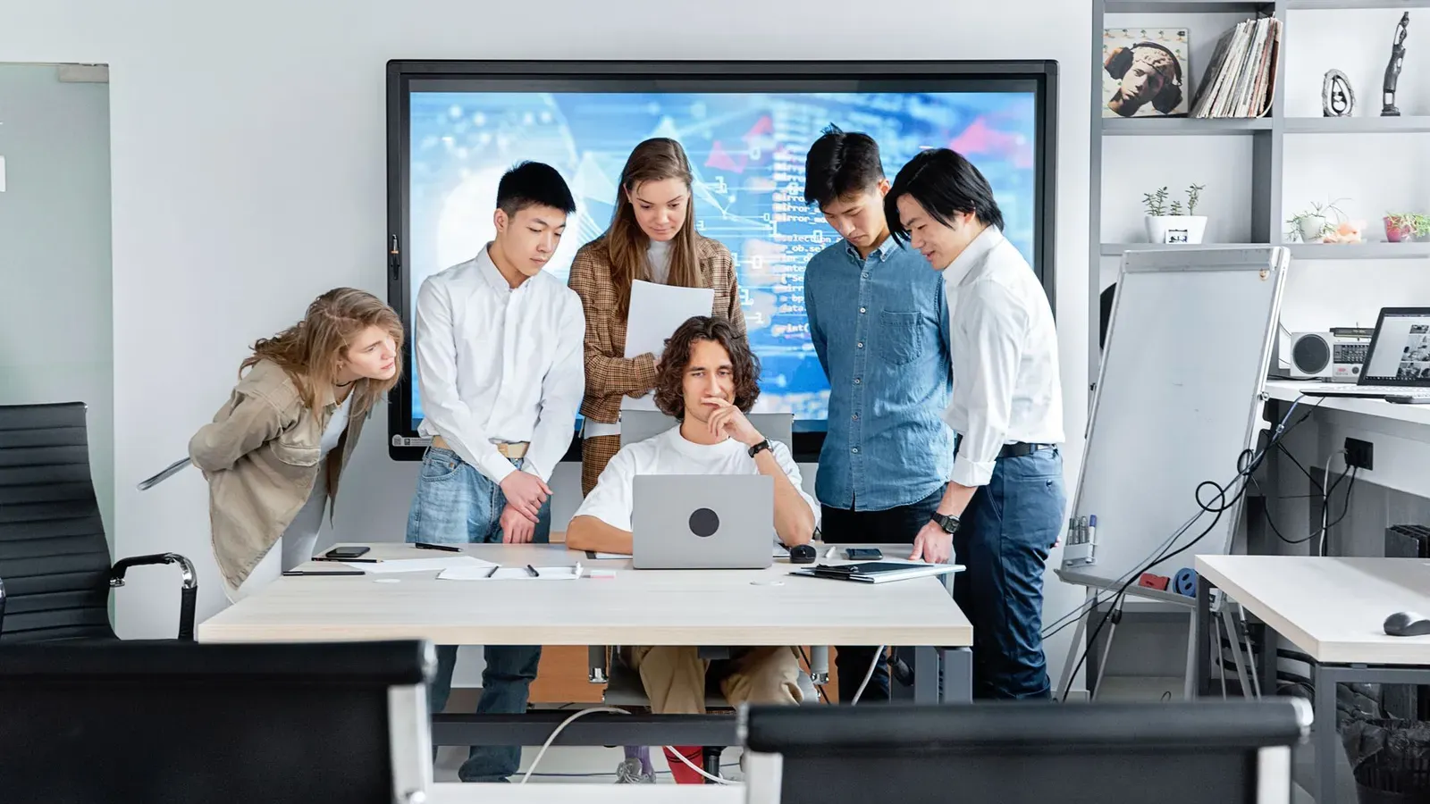 Diverse Teamarbeit an einem Softwareprojekt in einem modernen Büro.